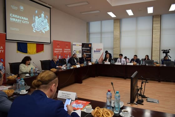 Robot de serviciu alături de un copil și de participanți, într-o sală.