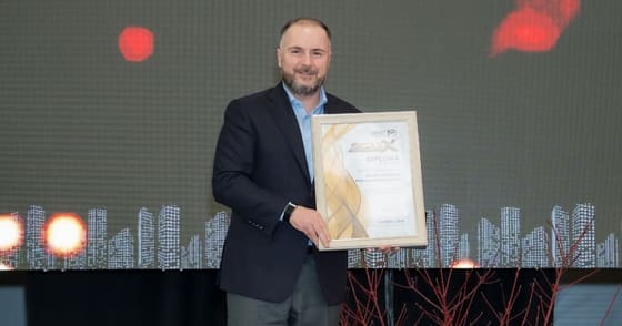 Participant pe scenă, cu diploma primită în mâini.