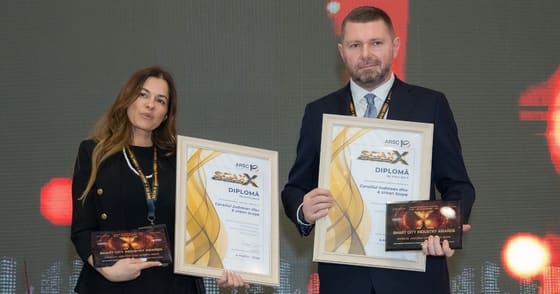 Două persoane ținând diplome și trofee SCIA X.